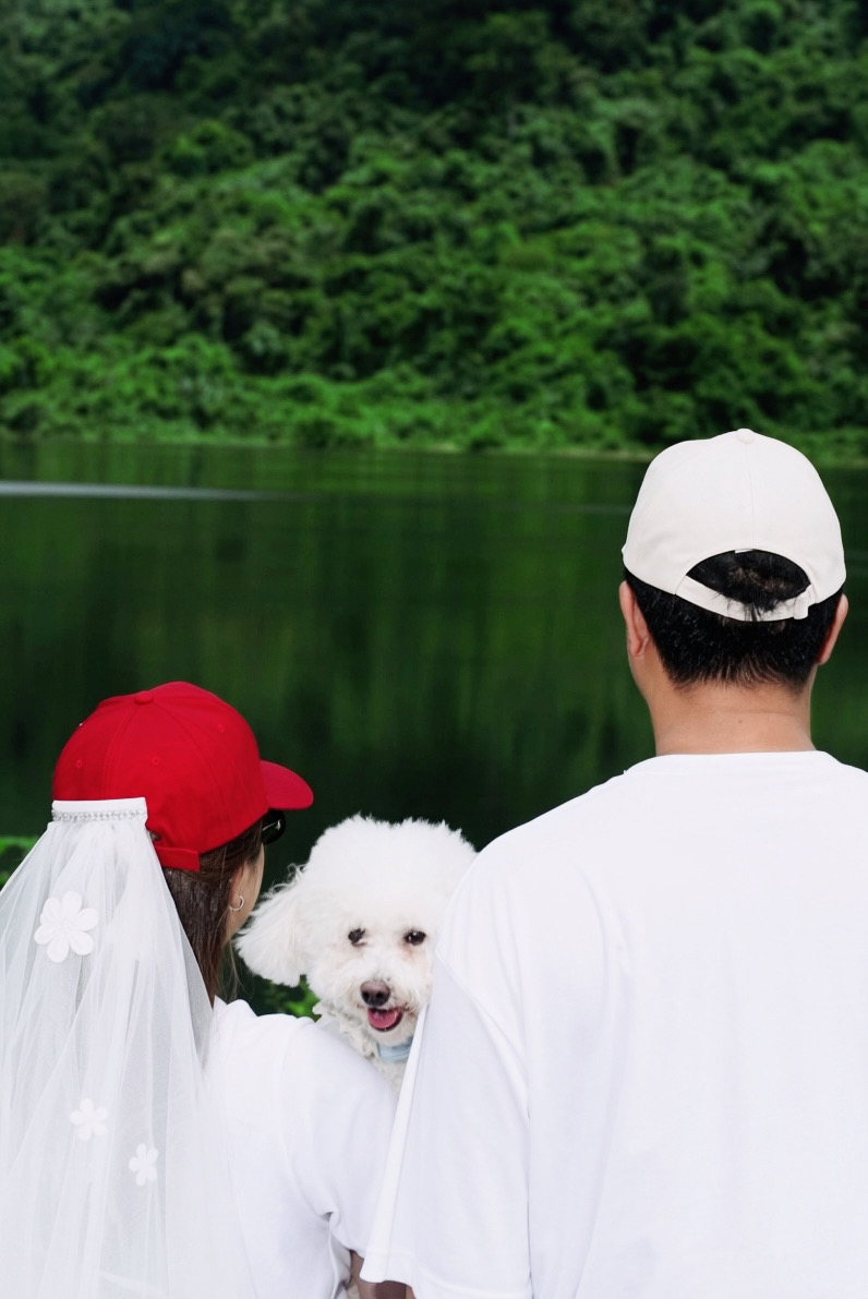 'Kham-pom และ Puen ยืนเคียงกันริมน้ำ โดยมีน้องหมาหันมามองกล้อง